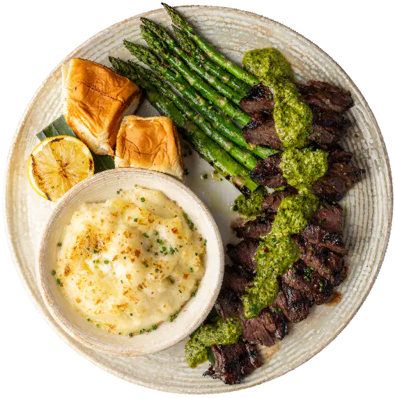 Pacific Catch Chimichurri Skirt Steak with grilled asparagus, creamy mashed potatoes, toasted rolls and grilled lemon.