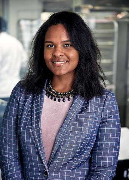 a woman wearing a blue blazer and smiling at the camera