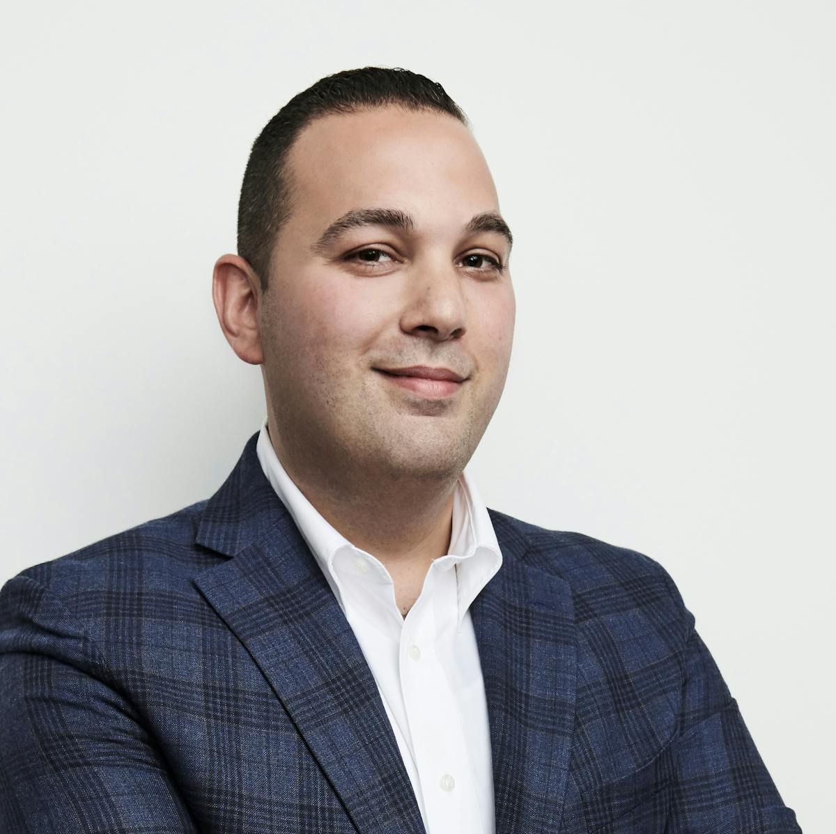 a man wearing a suit and tie smiling at the camera