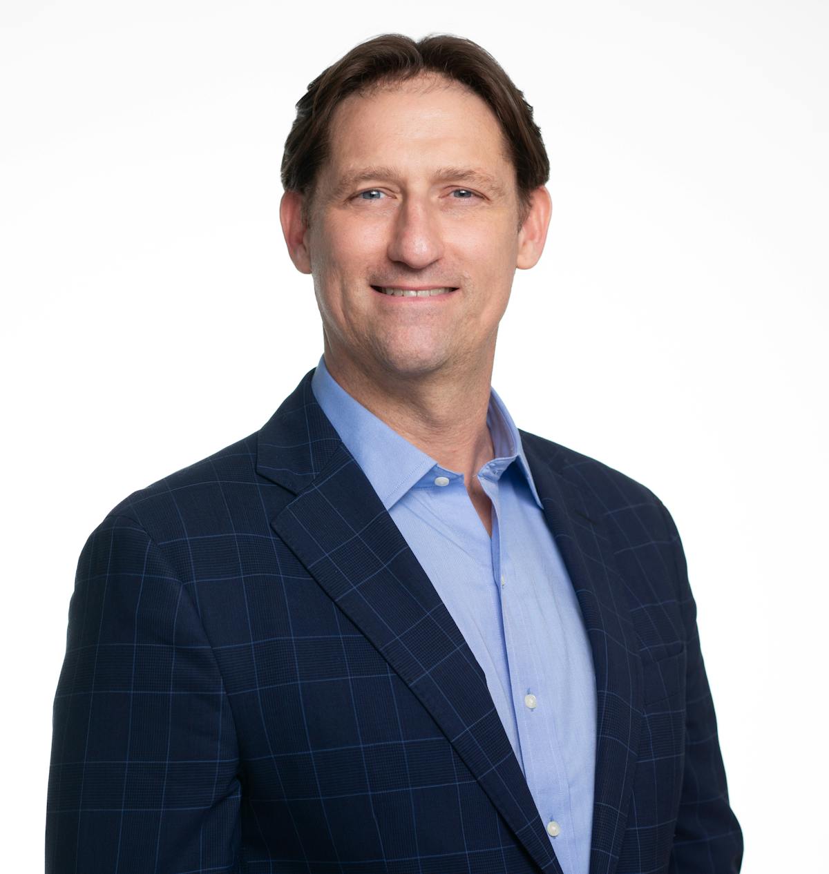 a man wearing a suit and tie smiling at the camera