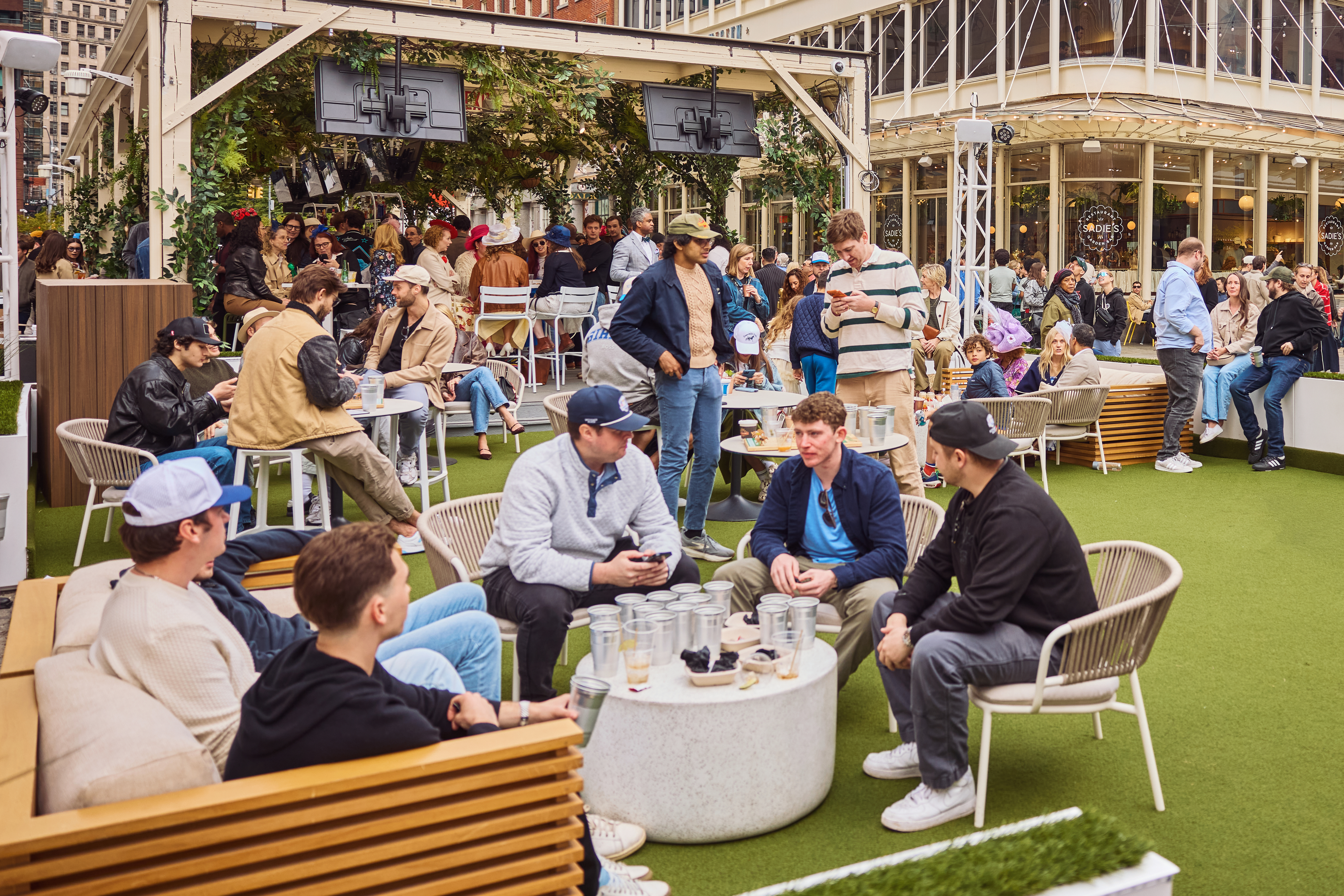 a group of people sitting around tables outside