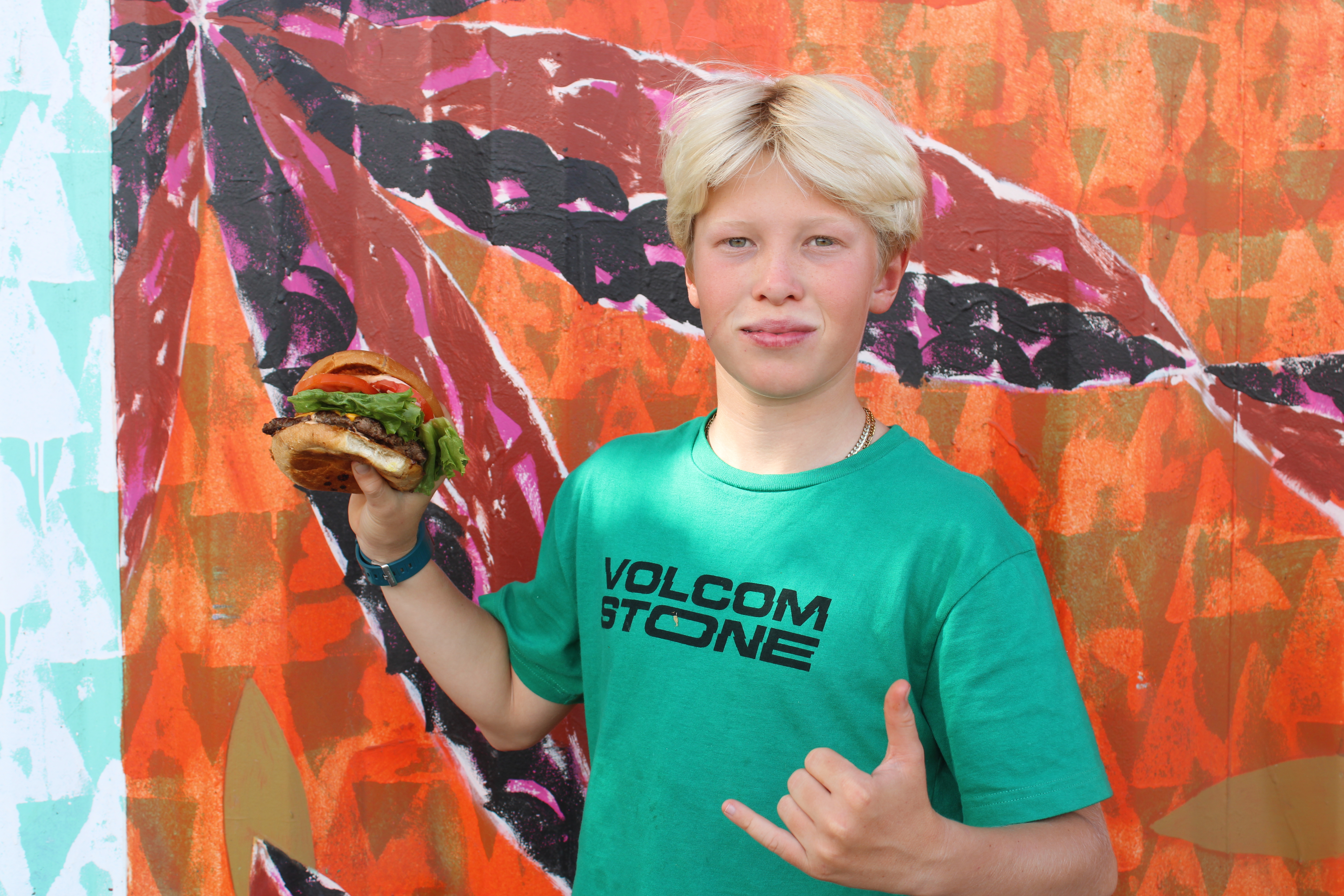 a young boy wearing a colorful shirt and smiling at the camera