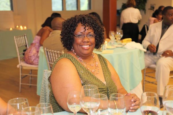 a woman sitting at a table with wine glasses