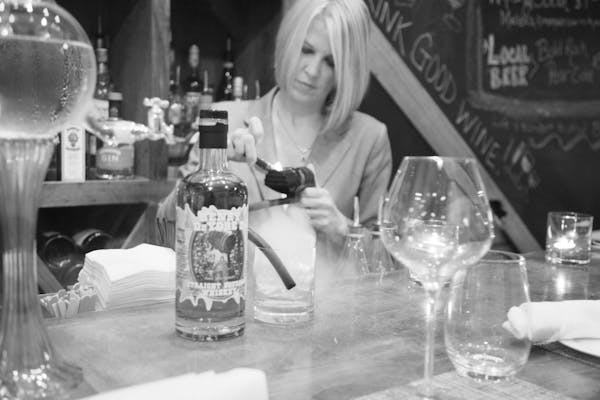 a woman sitting at a table with wine glasses