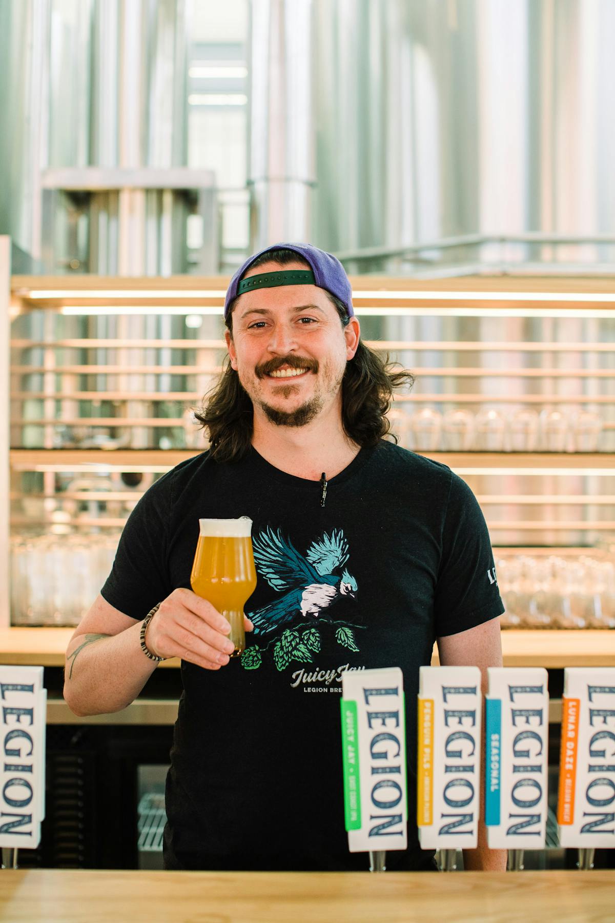a person holding a glass of beer on a table