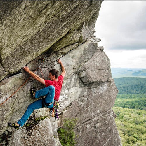 a person standing in front of a large rock