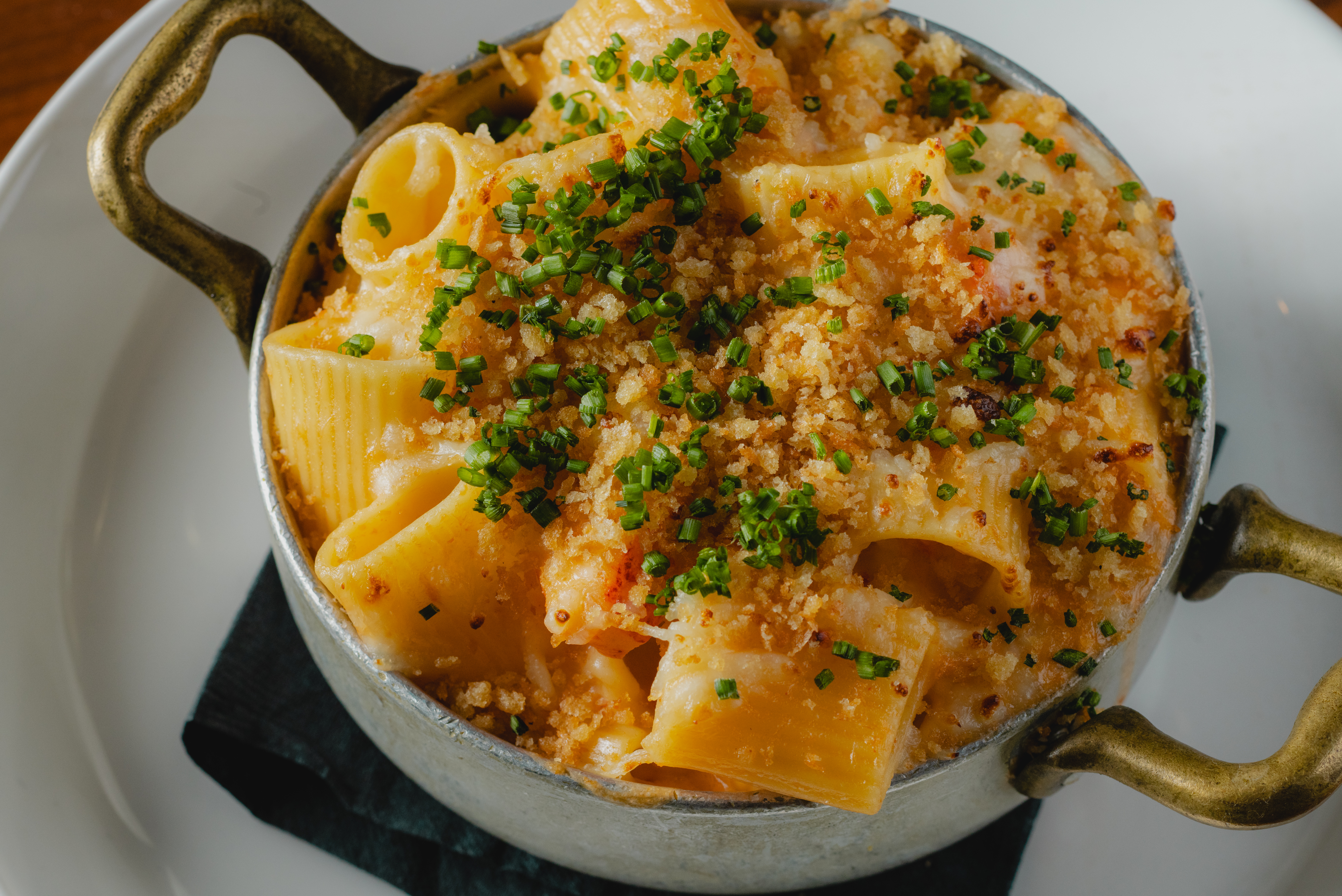 a pot of pasta with crumbs and green onions
