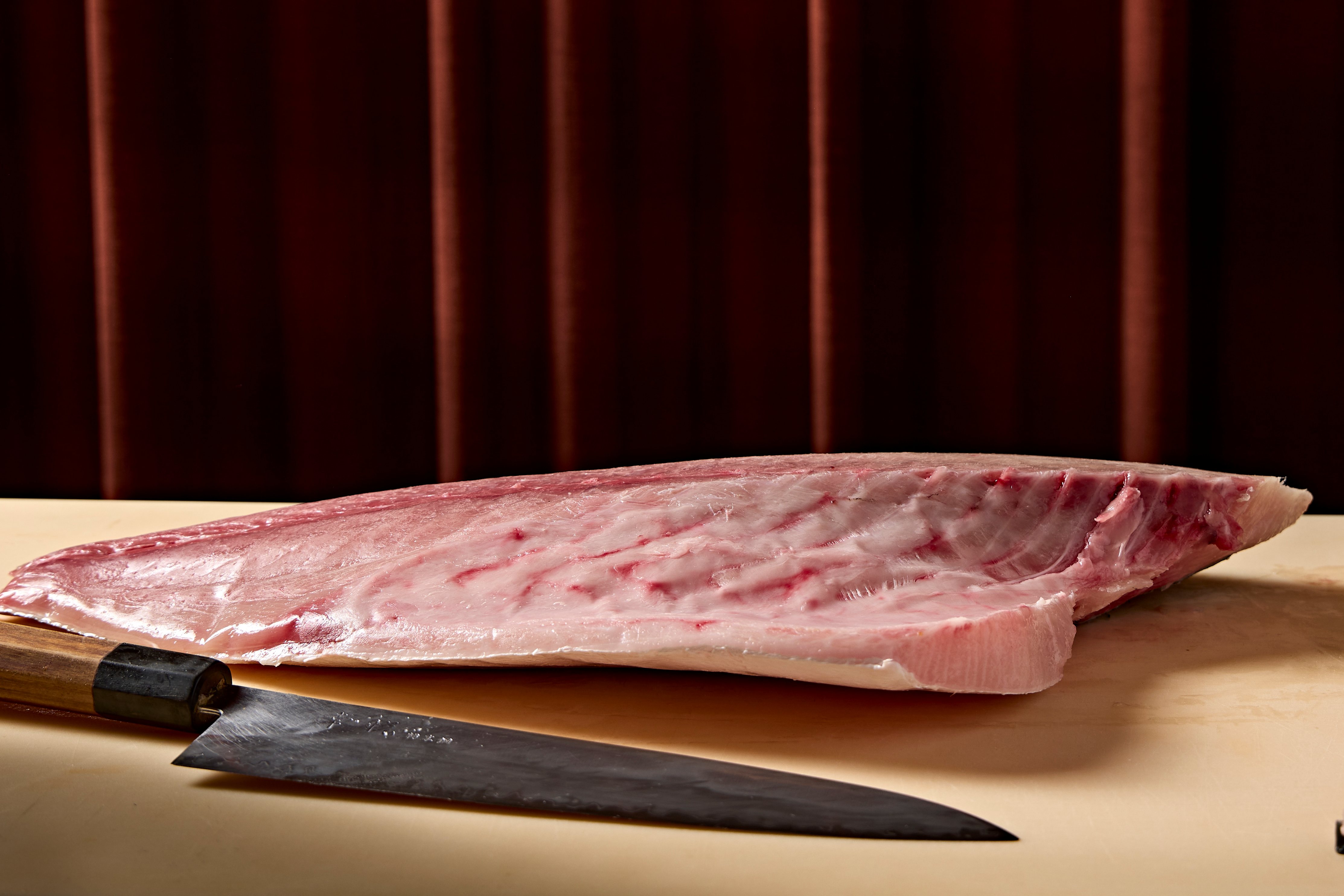 a piece of meat on a table with a knife