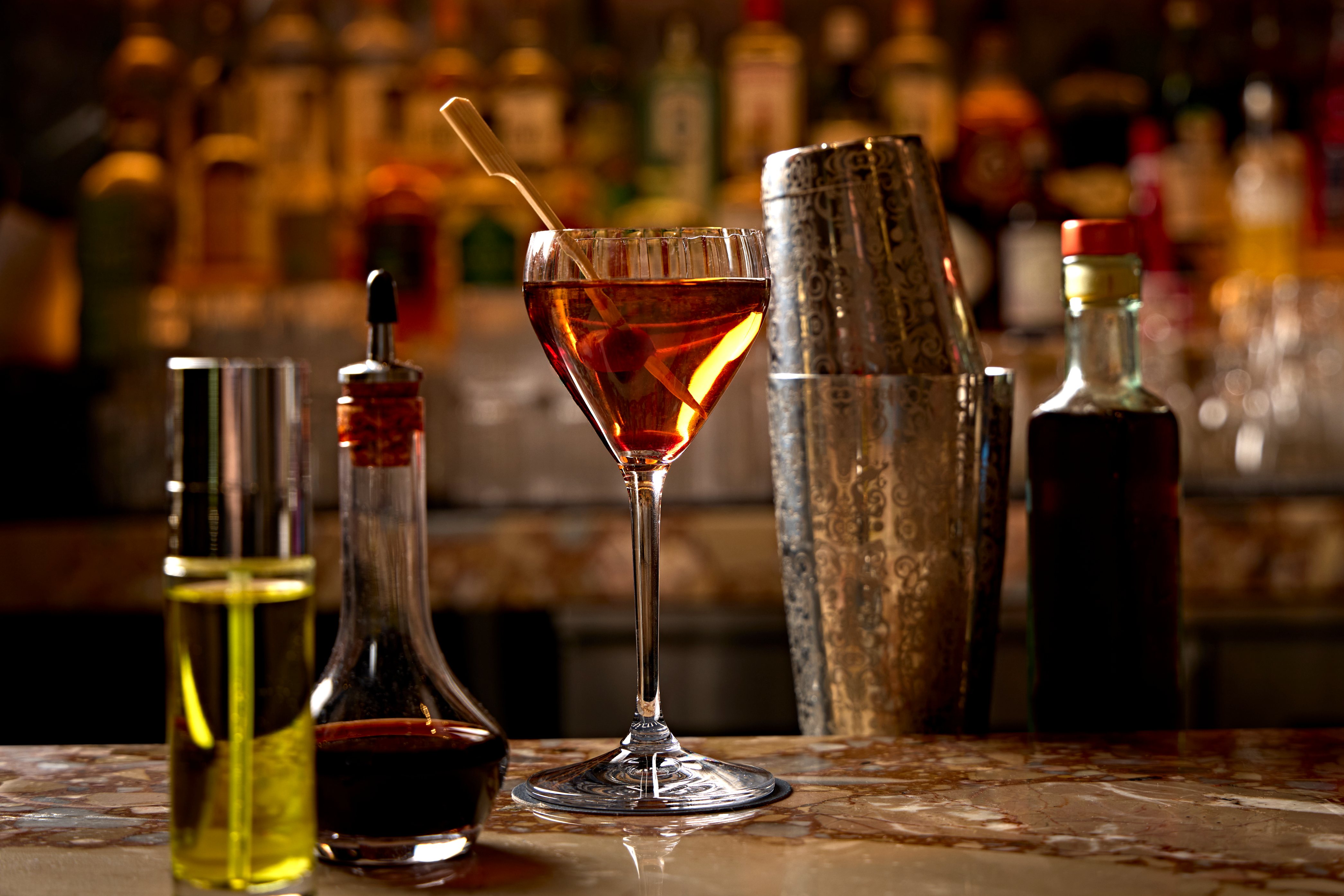 a glass of brown liquid with a wooden spoon in it