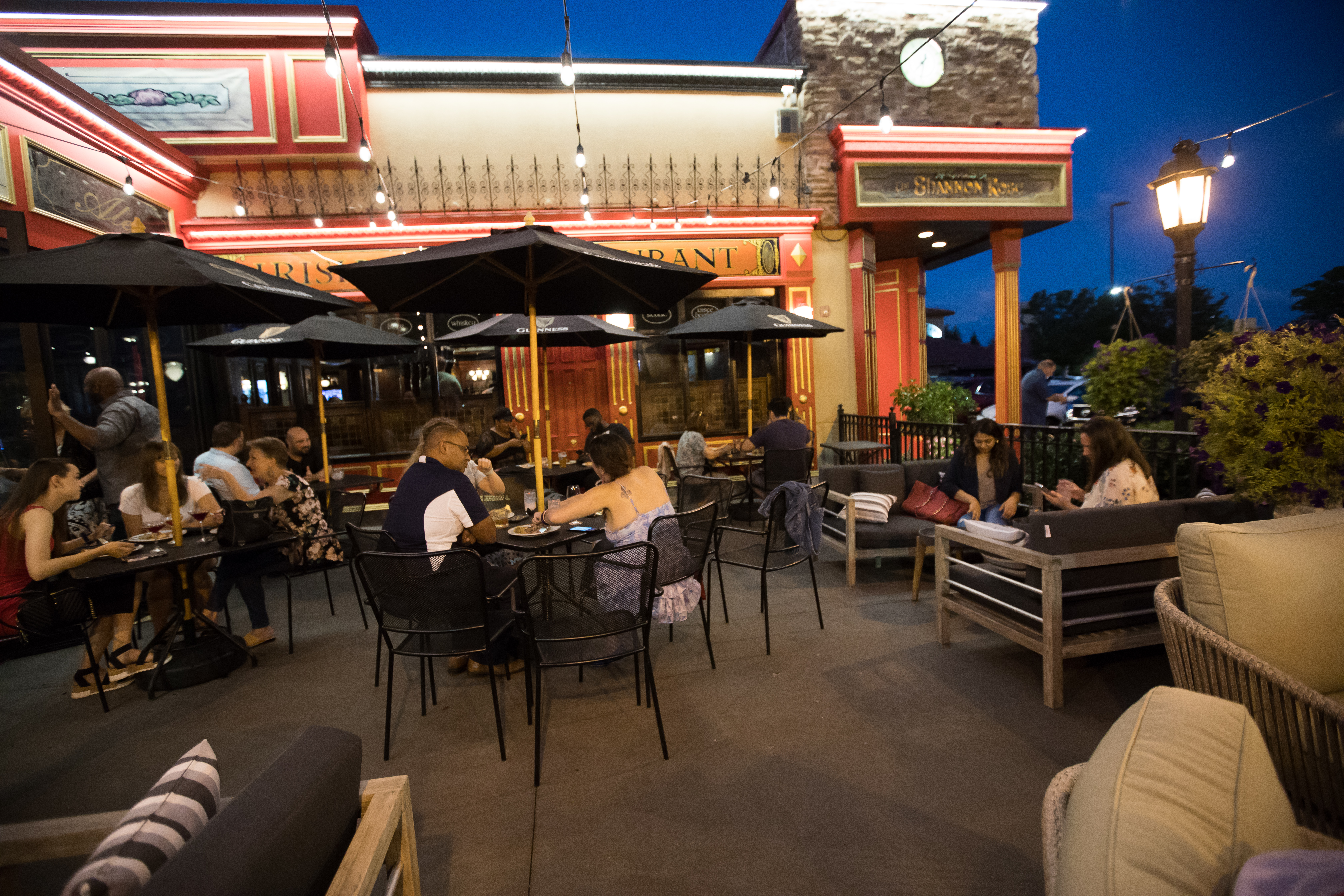 a group of people sitting at a table in front of a building