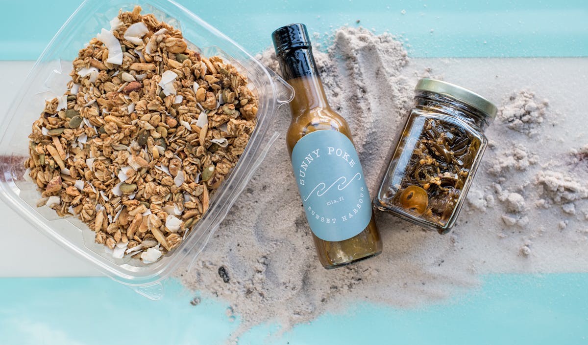 a close up of a beer bottle and a bowl full of granola