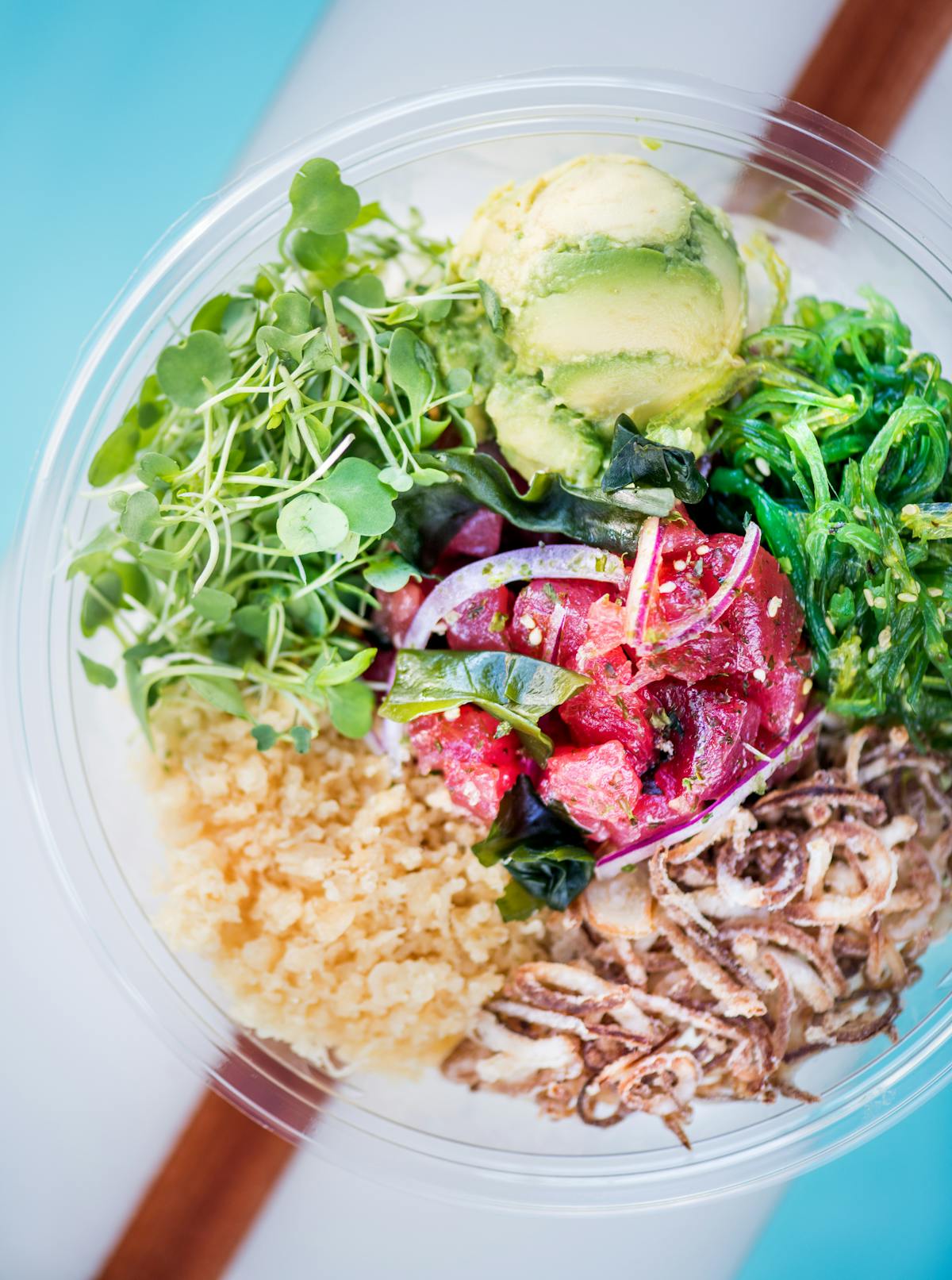 a close up of a bowl salad on a wooden surface