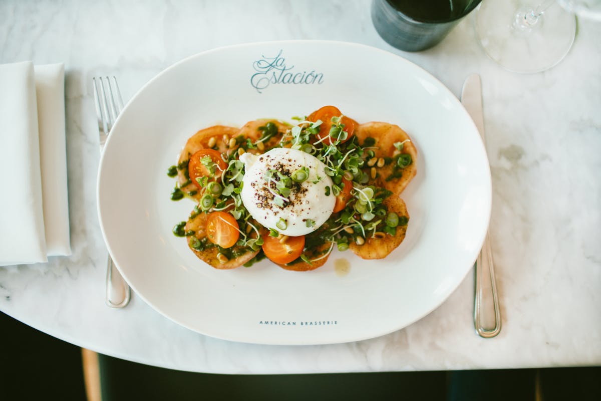 a white plate topped with sauced tomato and eggs