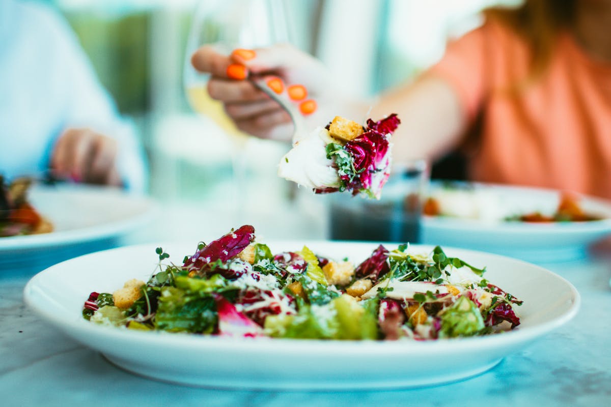 a close up of a plate topped with salad and croutons