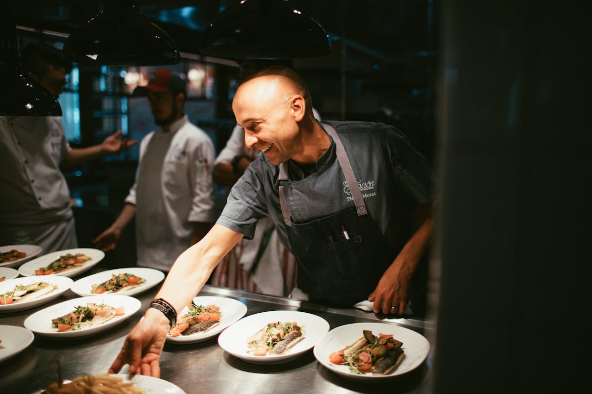 a man serving food on an open kitchen bar