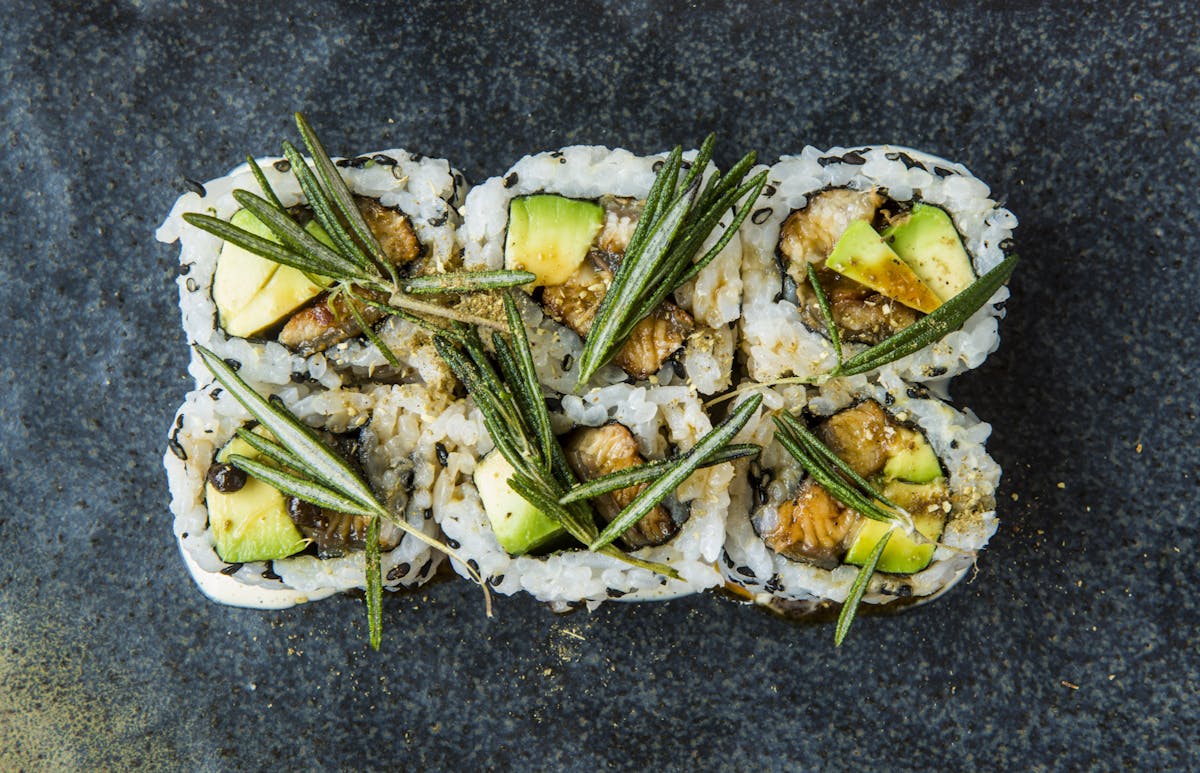 a close up of sushi rolls with avocado