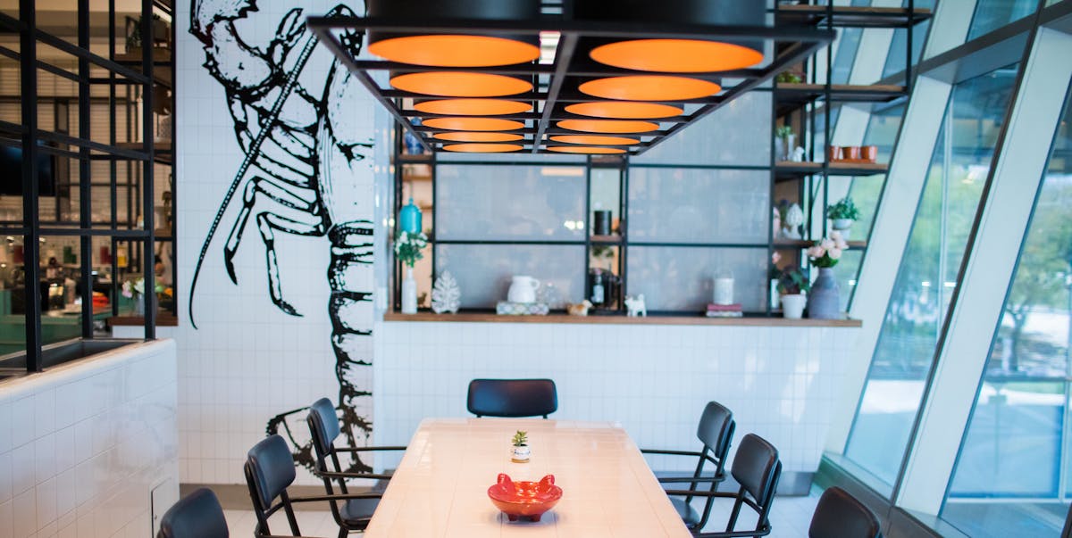 a dining room filled with a large dining table sided by chairs