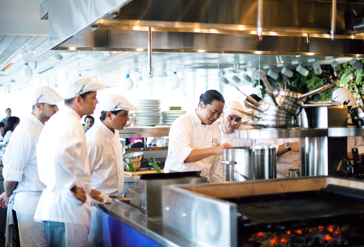a group of people preparing food in a commercial kitchen