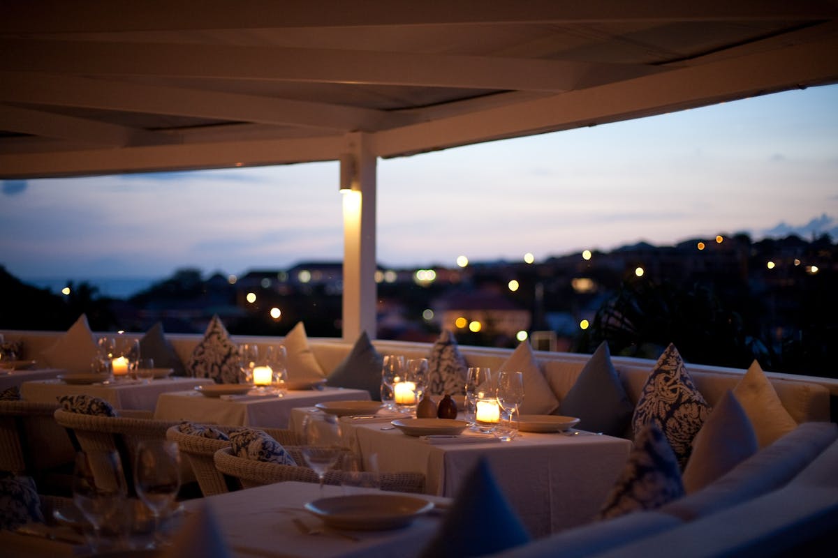 a terrace at night filled with tables and chairs