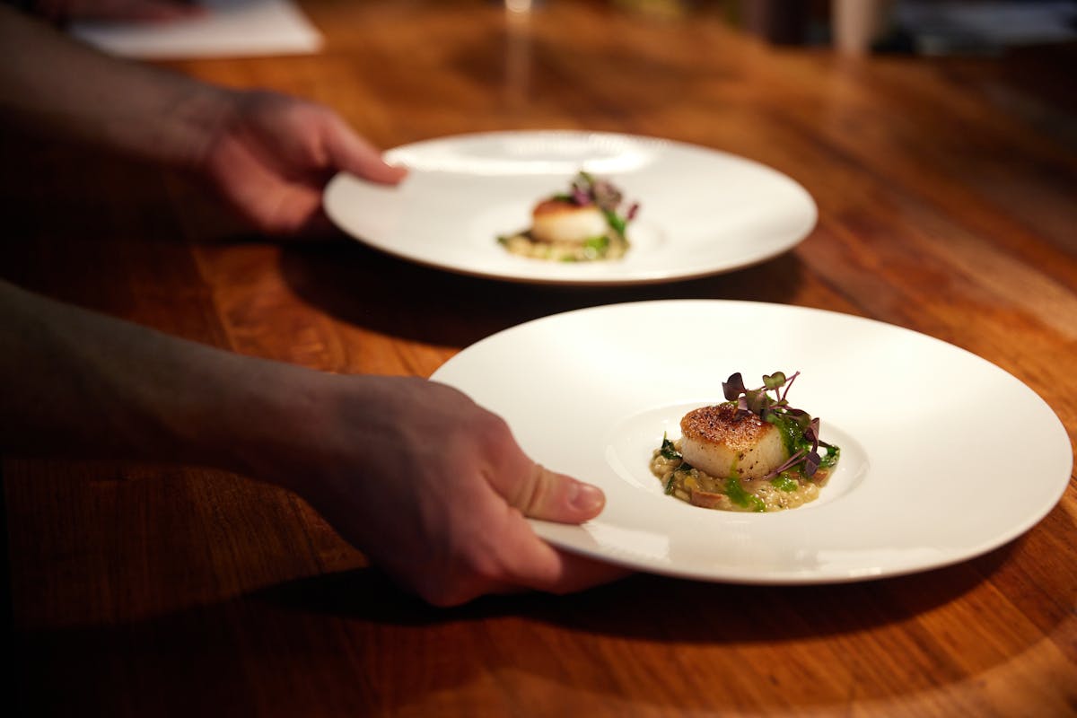 a person sitting at a table with a plate of food