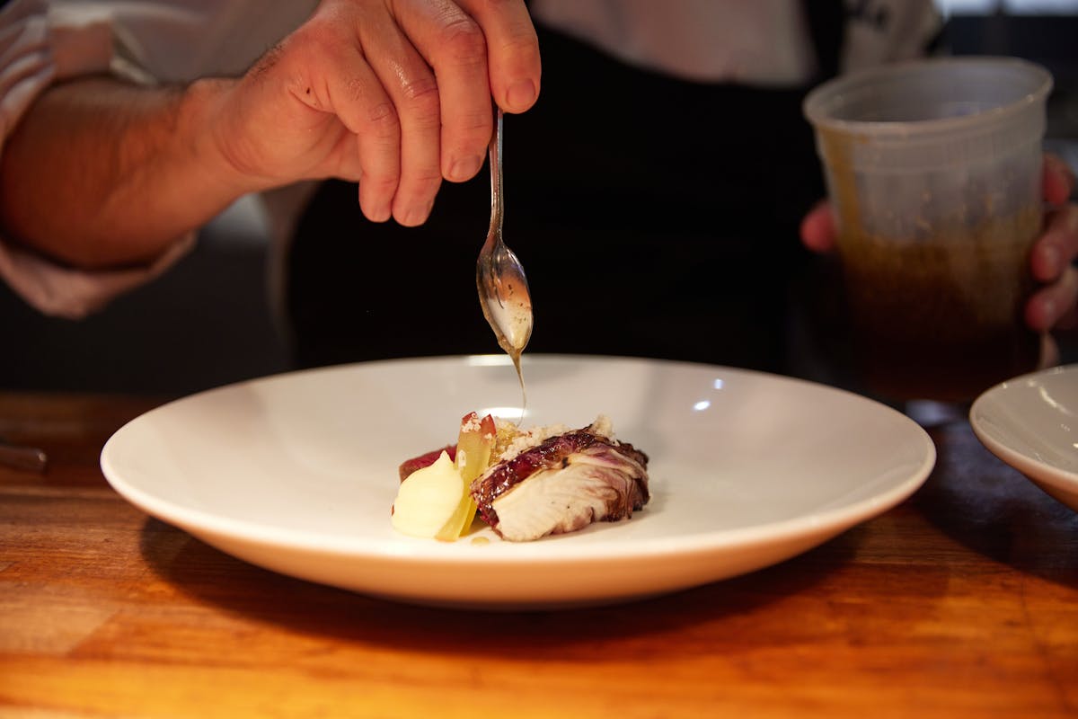 a person sitting at a table with a plate of food with a fork