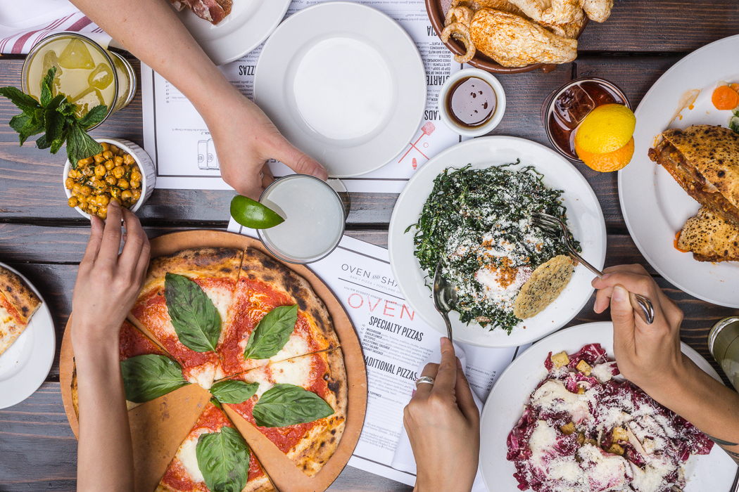 a group of people sitting at a table with a plate of food