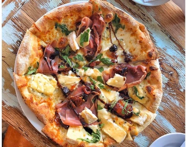 a pizza sitting on top of a wooden table
