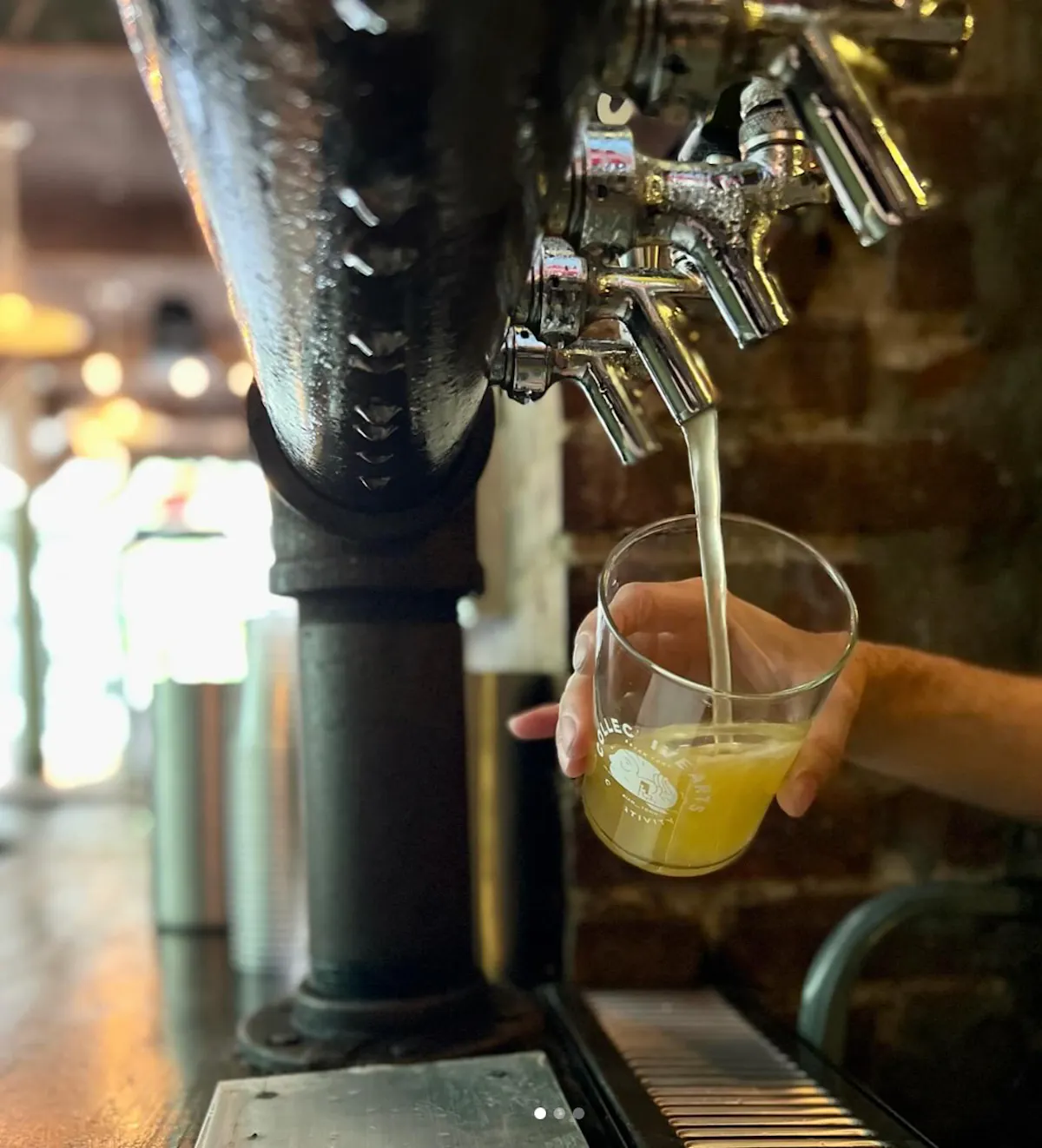 a person pouring a drink from a tap