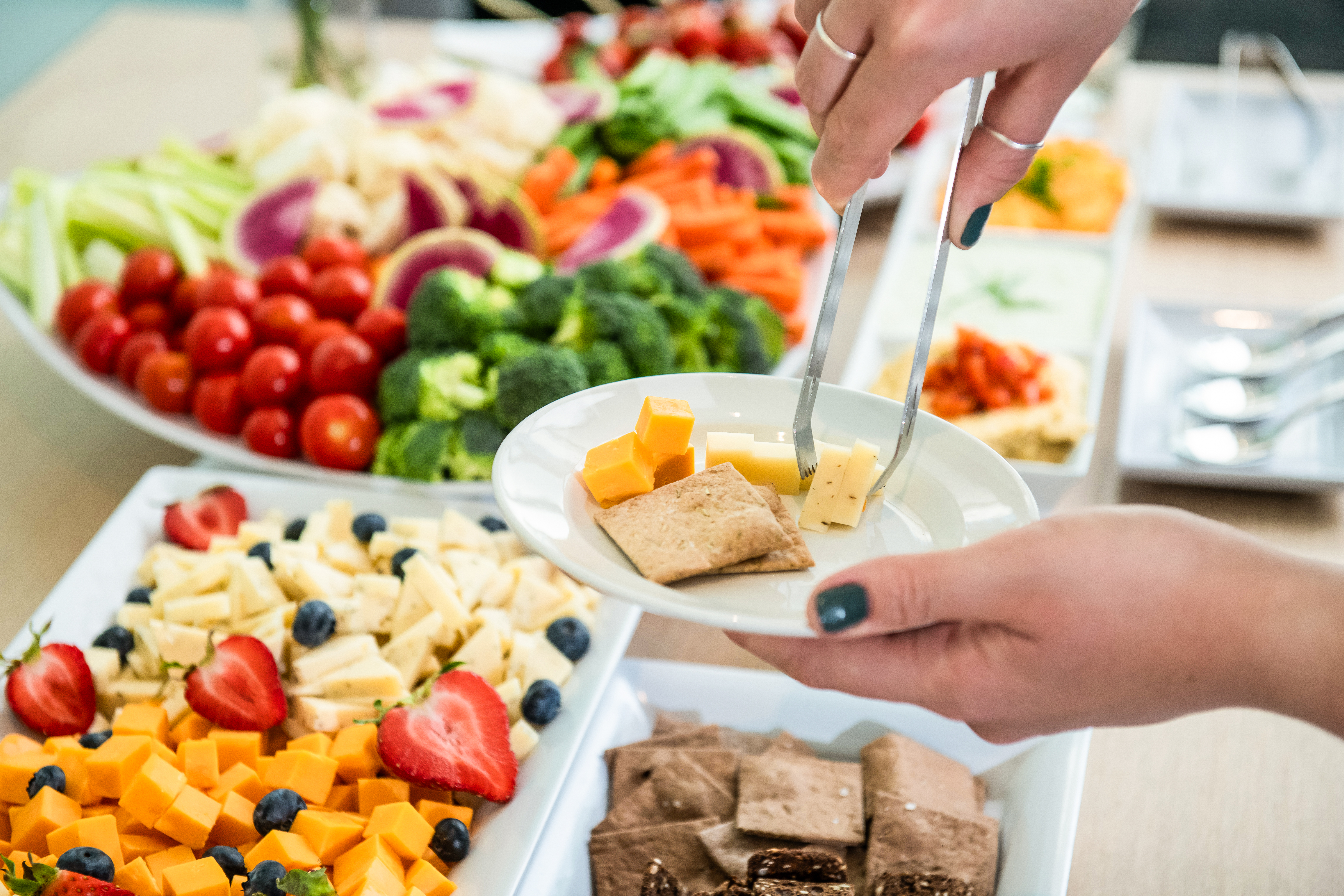 a person holding a plate of food on a table