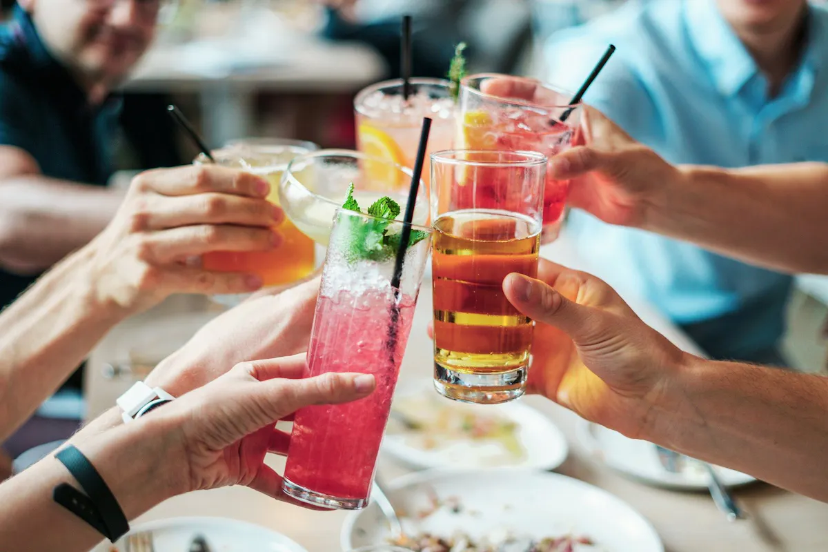 a person sitting at a table with food and drinks