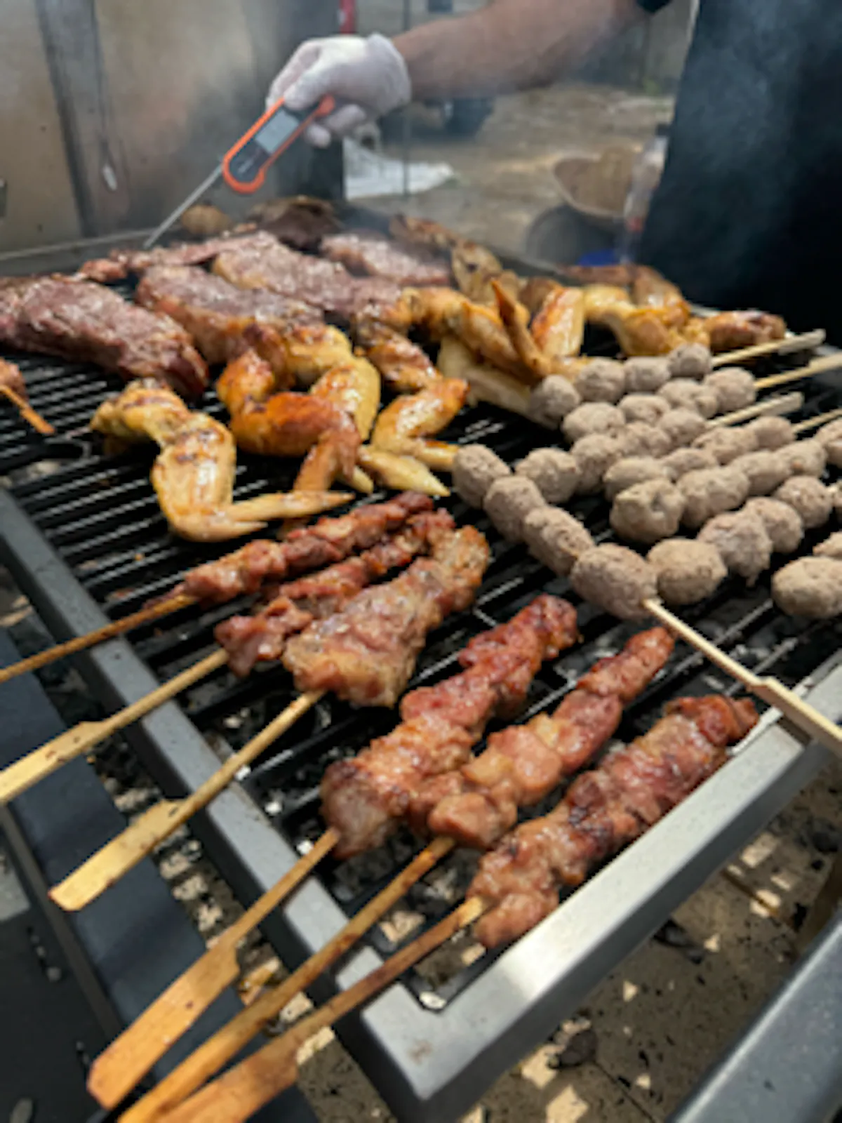 a pile of hot dogs cooking on a grill