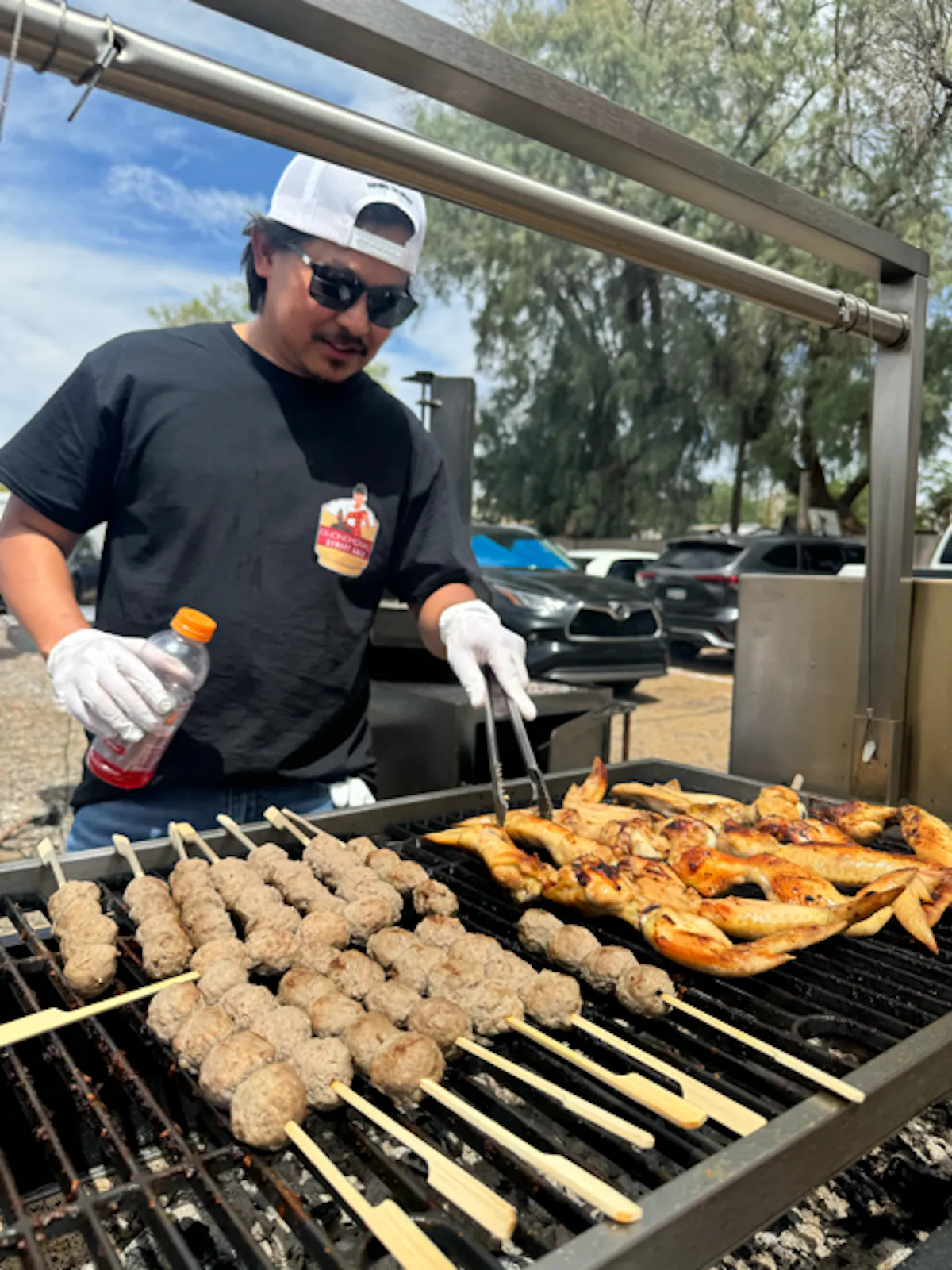 a man cooking hot dogs on a grill