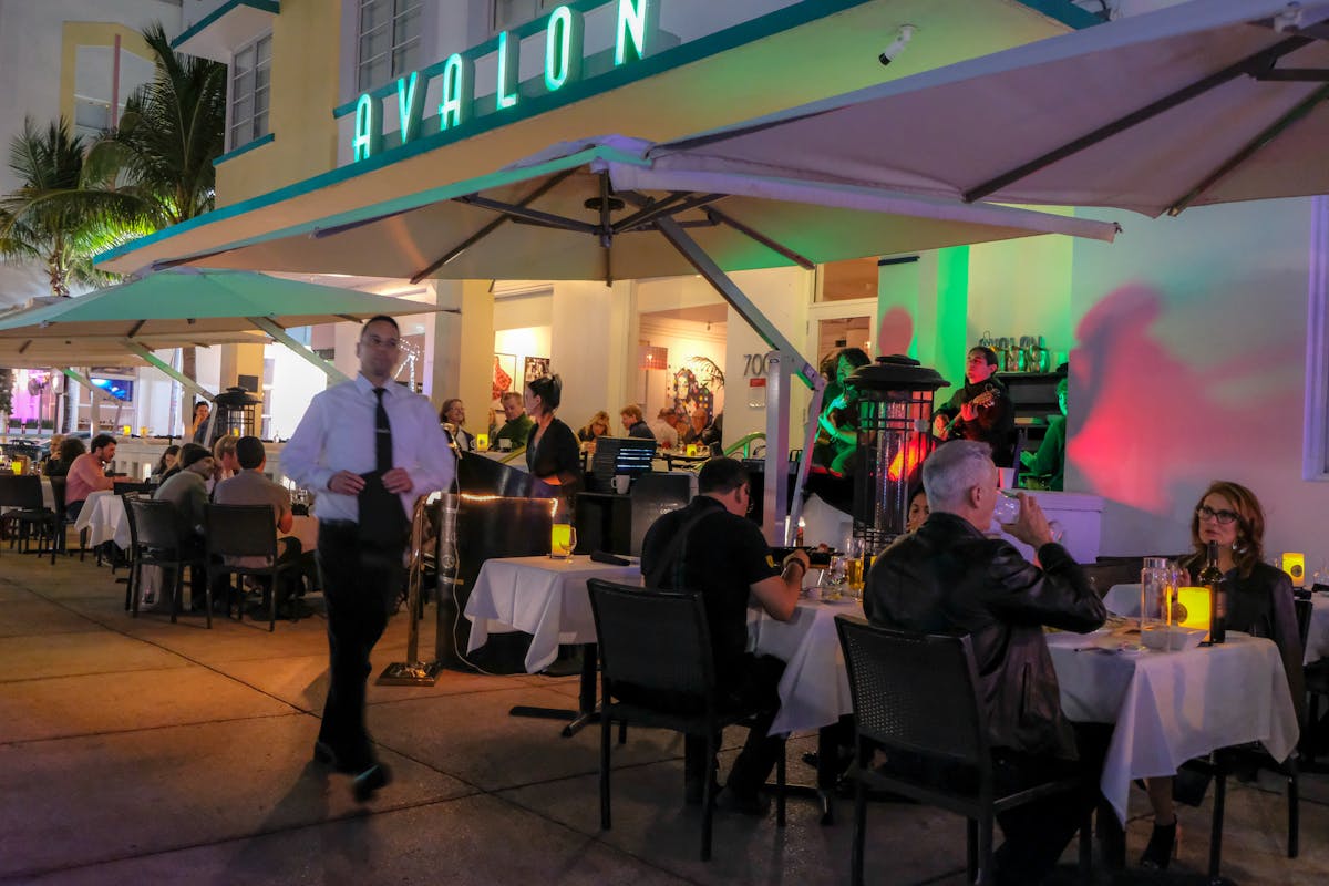 a waiter walking past the outdoor dining area of the A Fish Called Avalon restaurant
