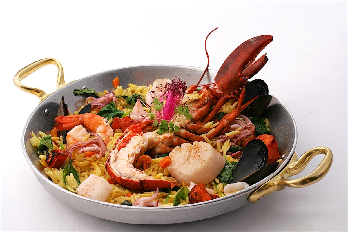 a close up of the Orzo Seafood Paella in a gray bowl