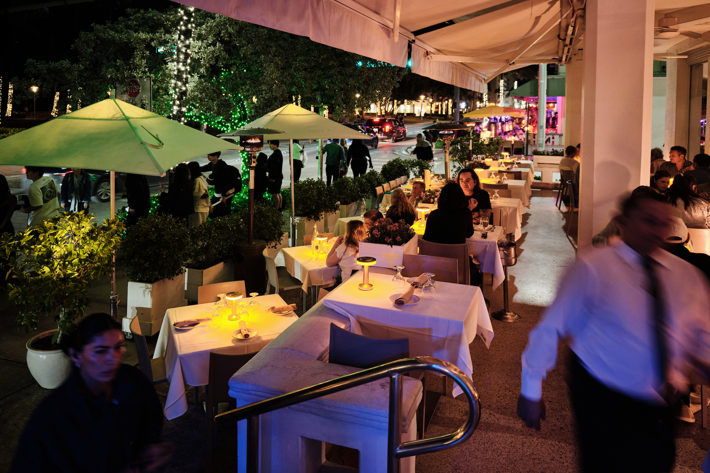 a group of people sitting at tables outside