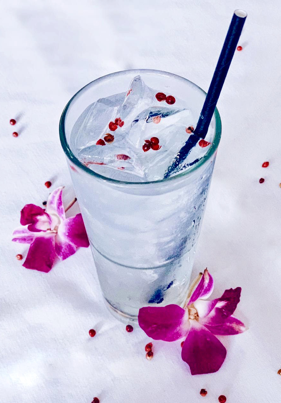a glass of water with ice and a straw