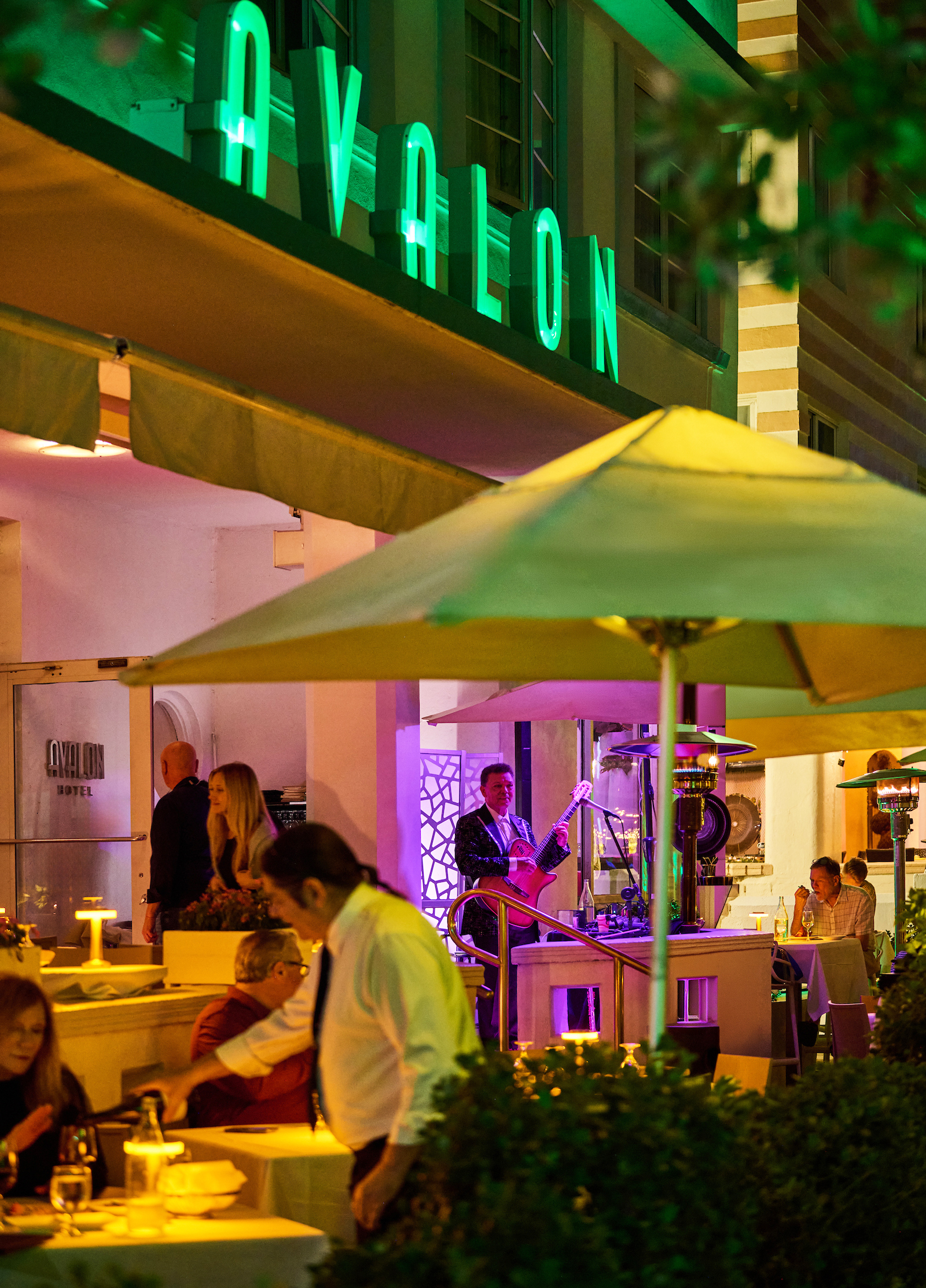a man playing a guitar in front of a building