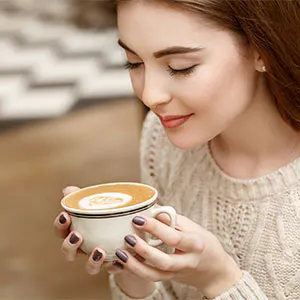a person sitting at a table with a cup of coffee
