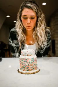 a person standing in front of a cake