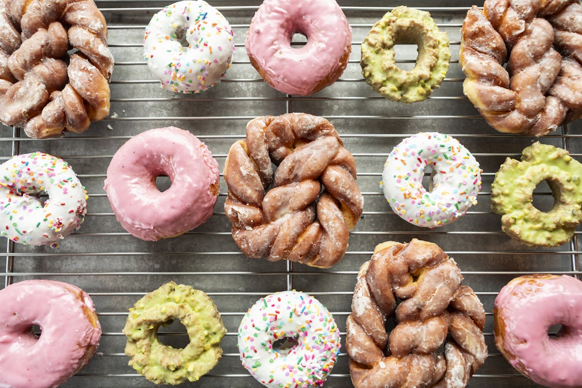 a group of assorted doughnuts on a grill