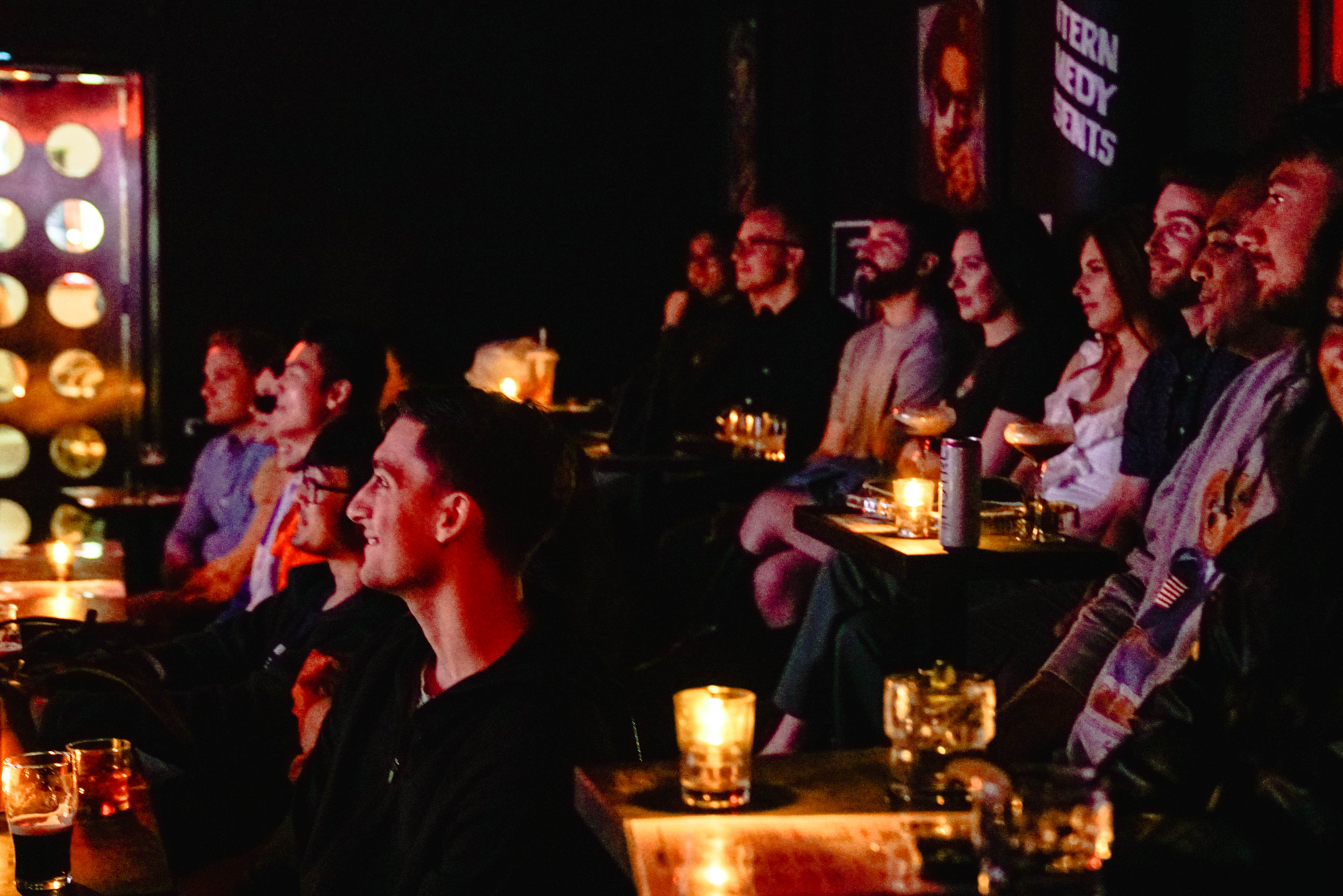 a group of people sitting in a room with candles