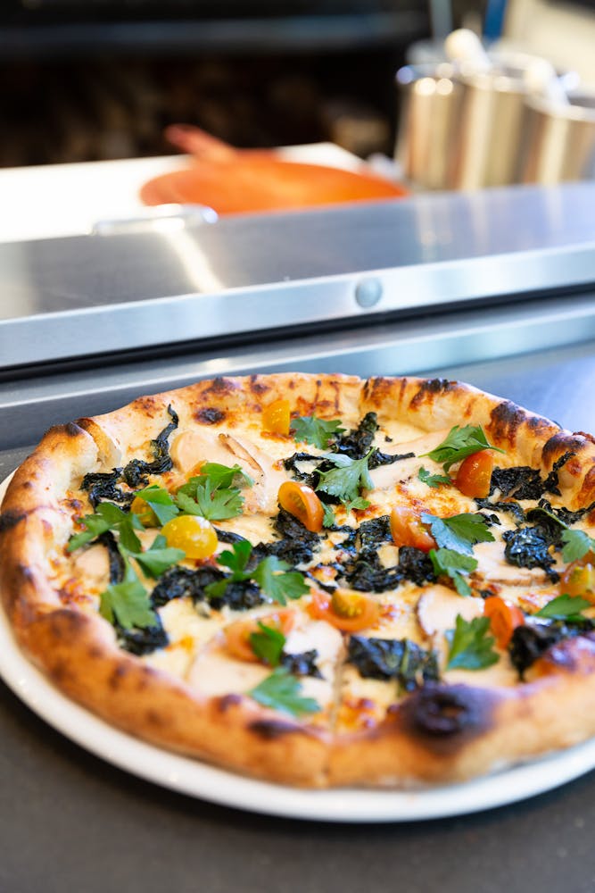 a pizza sitting on top of a plate of food on a table