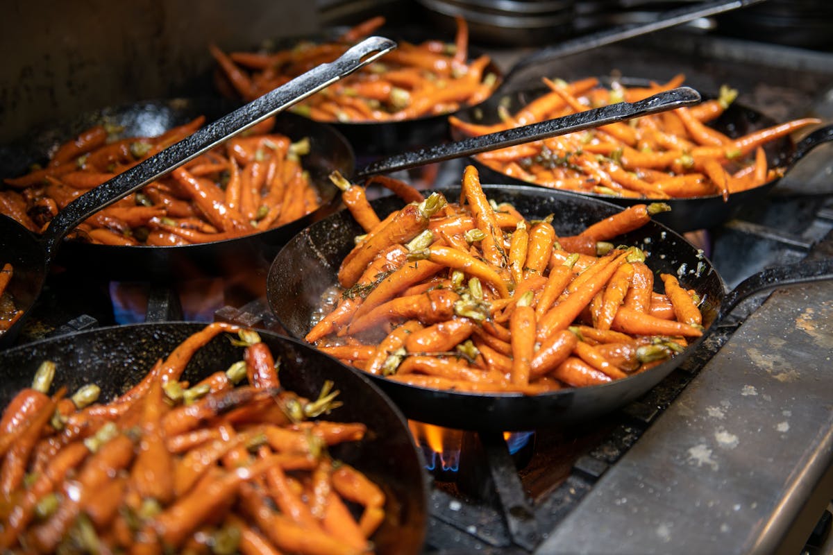 a tray of hot dogs cooking on a grill