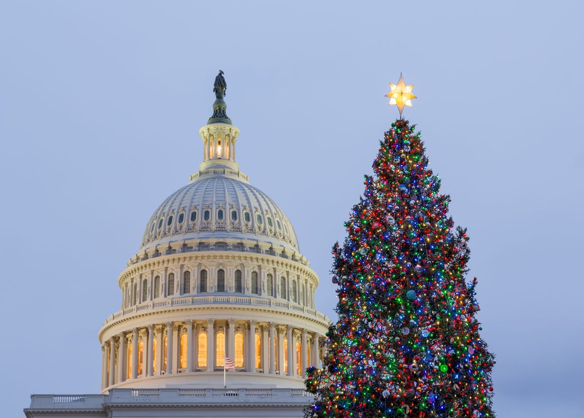 a large clock tower in front of United States Capitol