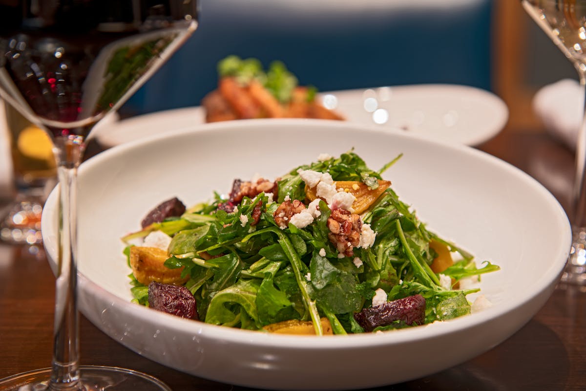 a plate of salad and a glass of wine