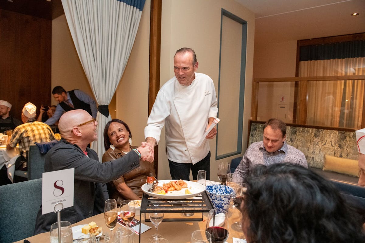 a group of people standing around a table