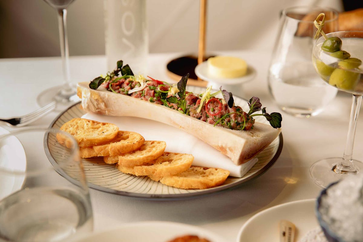 a plate of food and glasses of wine on a table