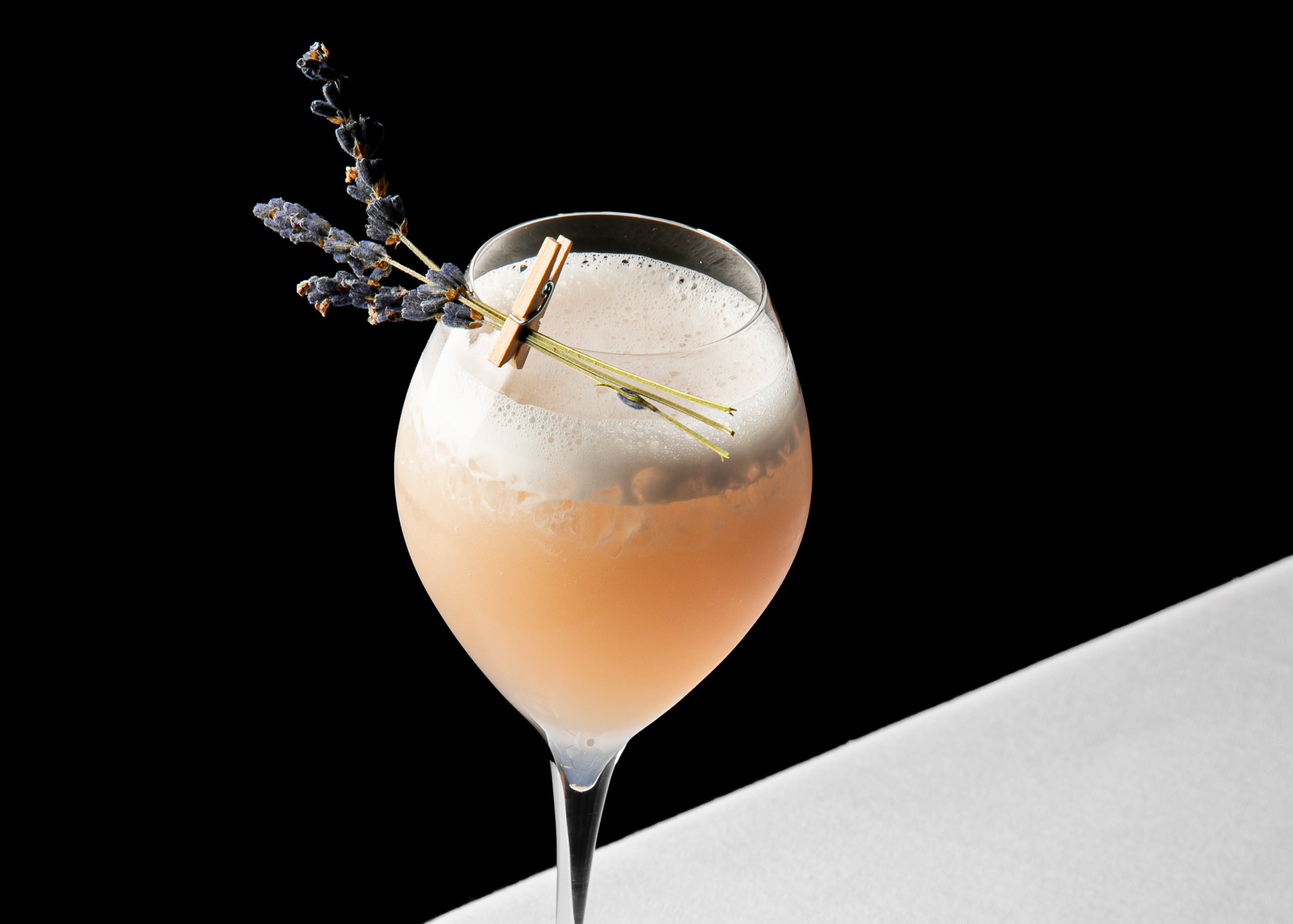 a glass of drink with lavender on top