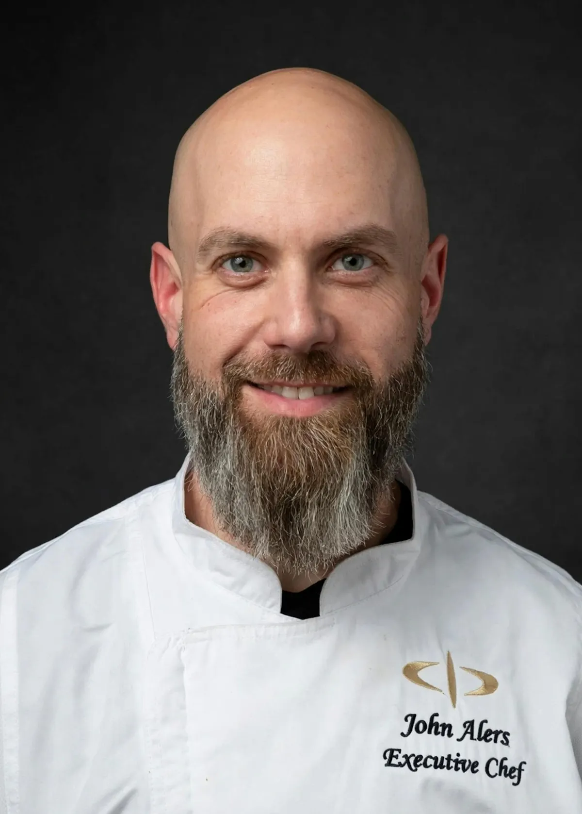 a man with a beard and mustache wearing a white chef's coat