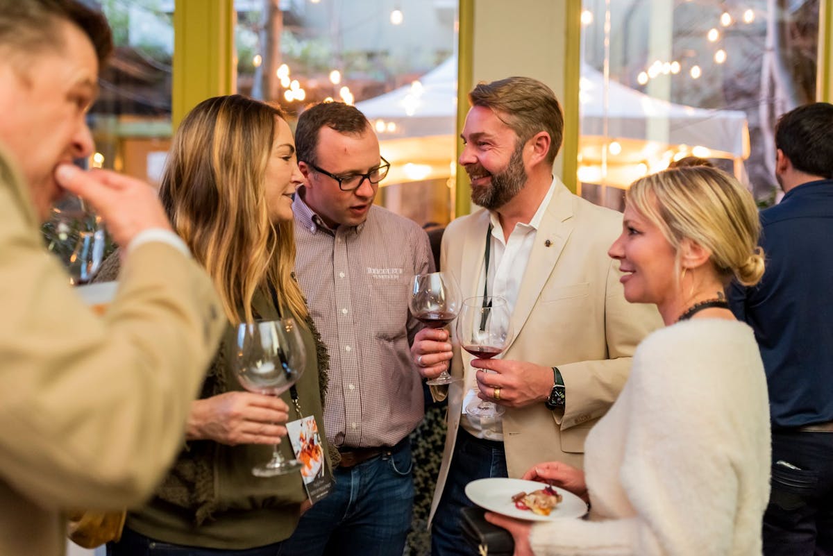 a group of people are drinking from a wine glass